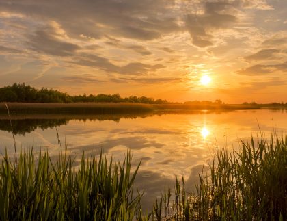 A beautiful orange, red, and yellow sunset above a vast lake.