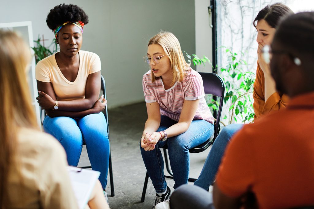 A circle of diverse women in group therapy.