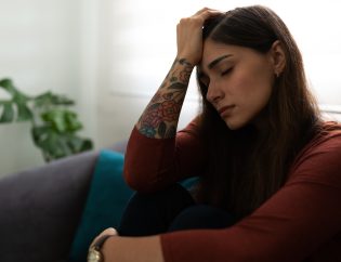 trauma response in women, an upset woman with her hand on her head.