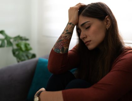 trauma response in women, an upset woman with her hand on her head.