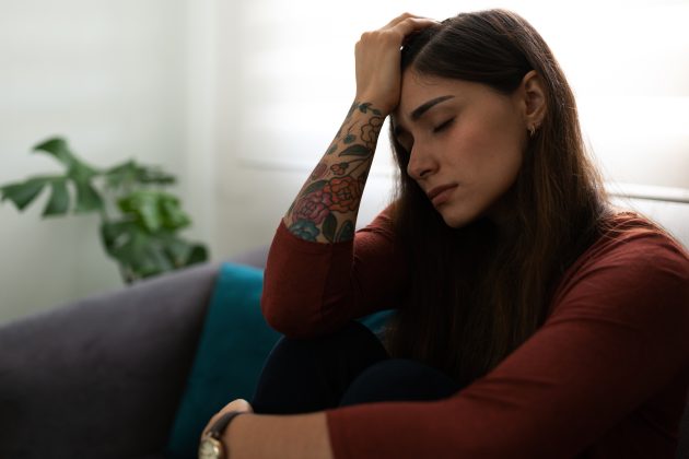 trauma response in women, an upset woman with her hand on her head.