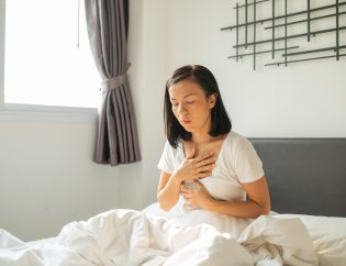 somatic therapy in recovery, represented by a young woman placing a hand on her chest and practicing slow breathing