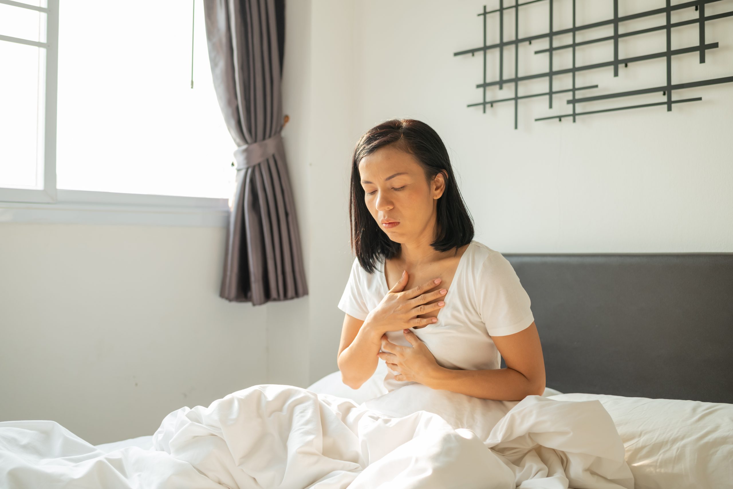 somatic therapy in recovery, represented by a young woman placing a hand on her chest and practicing slow breathing
